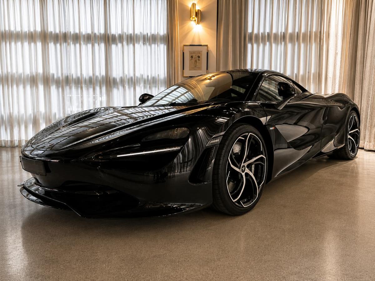 A black McLaren 750S supercar on display inside Verde Alexandria