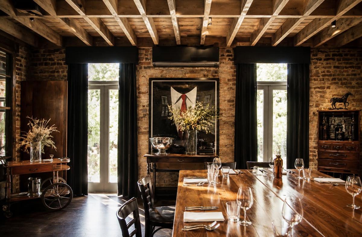 The Chairman&rsquo;s Room private dining room at Verde Darlinghurst, a long timber table beneath exposed brick walls and a timber-beam ceiling